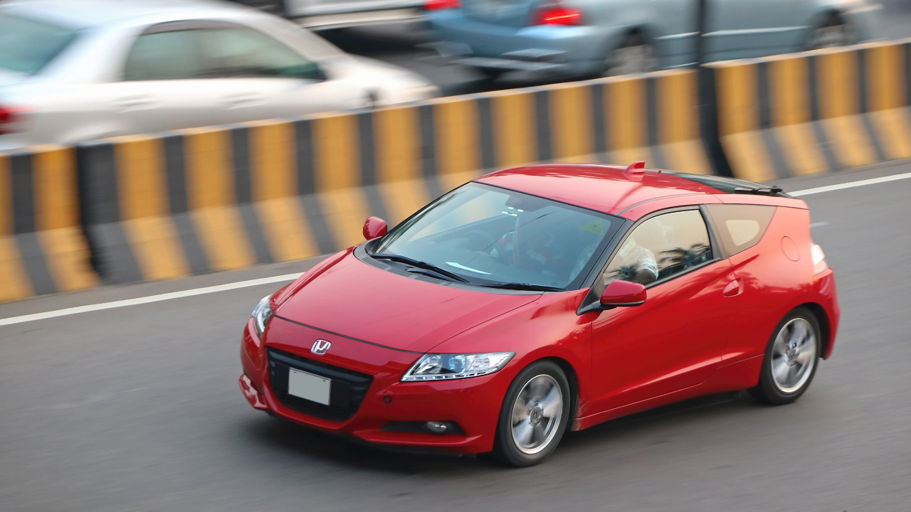 Red Honda CR-Z driven on an airport road