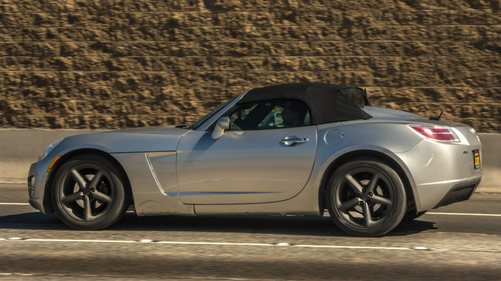 Side view of a silver Saturn Sky driving on highway