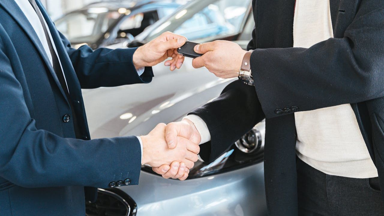 Person Giving a Car Key To Another Person