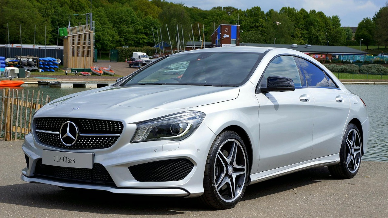 A sleek Mercedes-Benz CLA-Class car parked by a river, showcasing its luxury design.