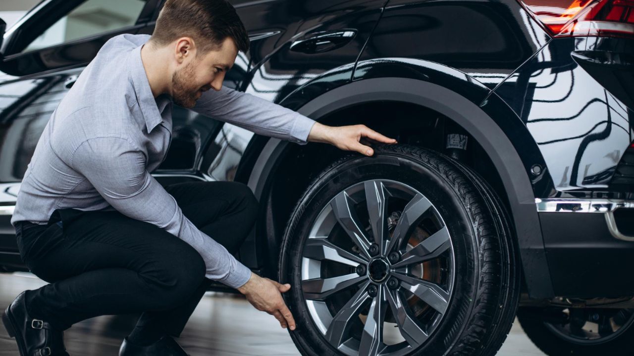 Man choosing a car and checking tires