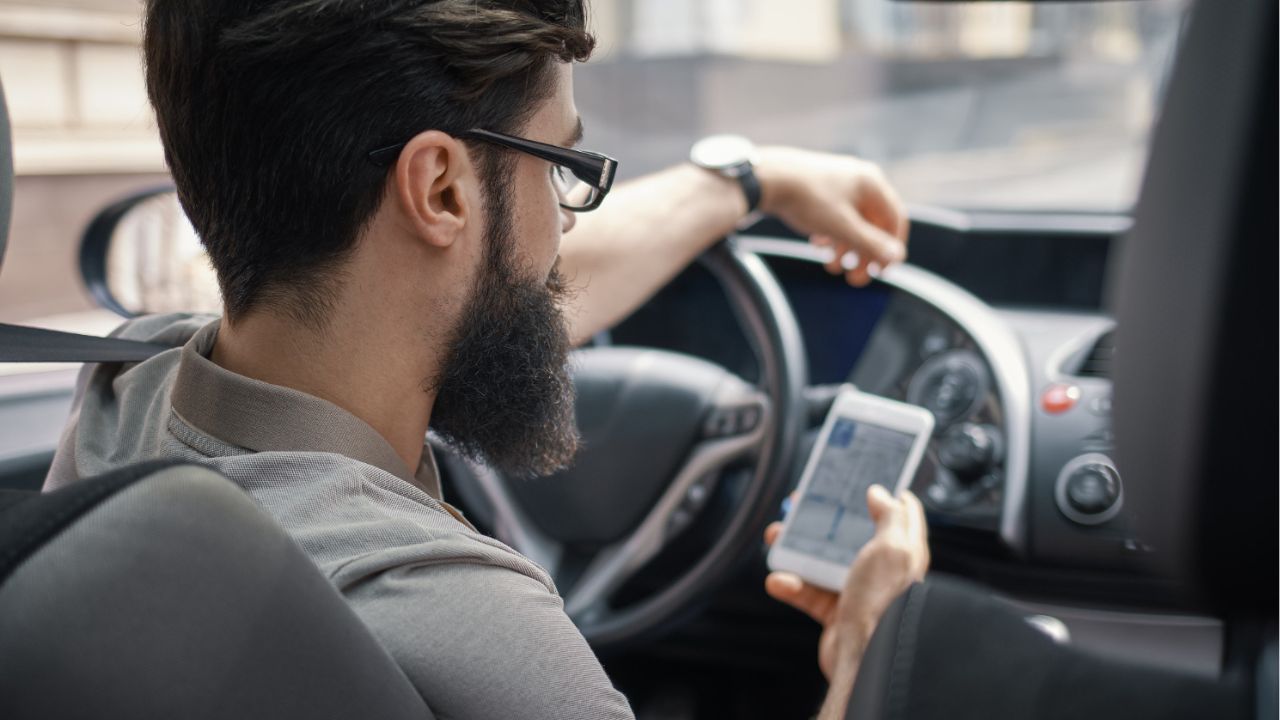 Man using mobile phone while driving.