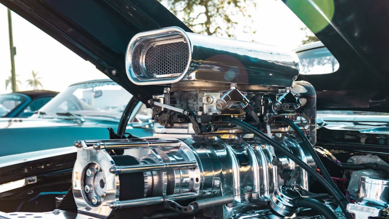 Close-up view of a high-performance engine in a classic car at an outdoor car show.