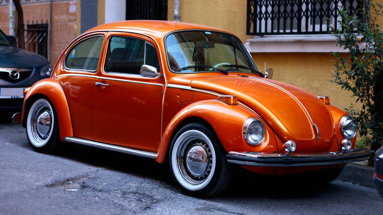 A classic orange Volkswagen Beetle parked on a street in Istanbul.