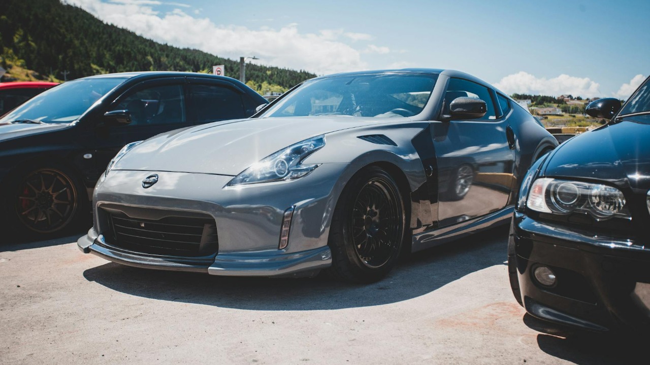 Silver Nissan Z-Car parked in a sunny outdoor lot, showcasing sleek design.