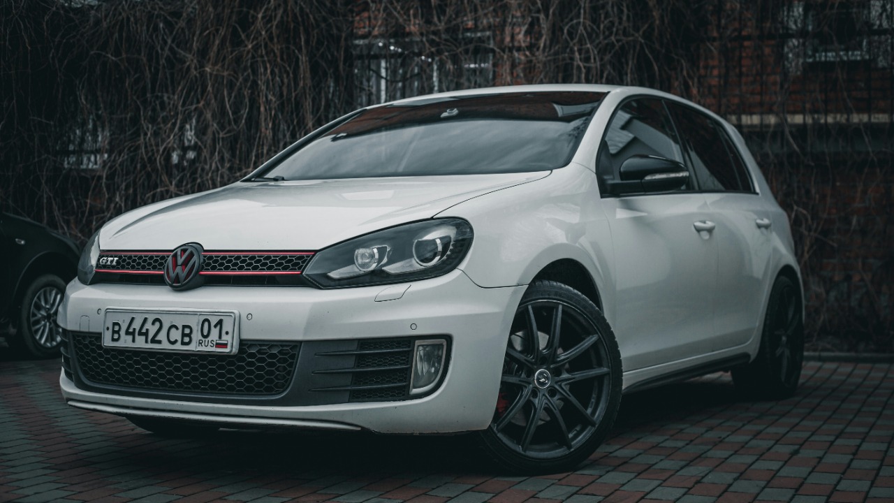 a white car parked in front of a brick building
