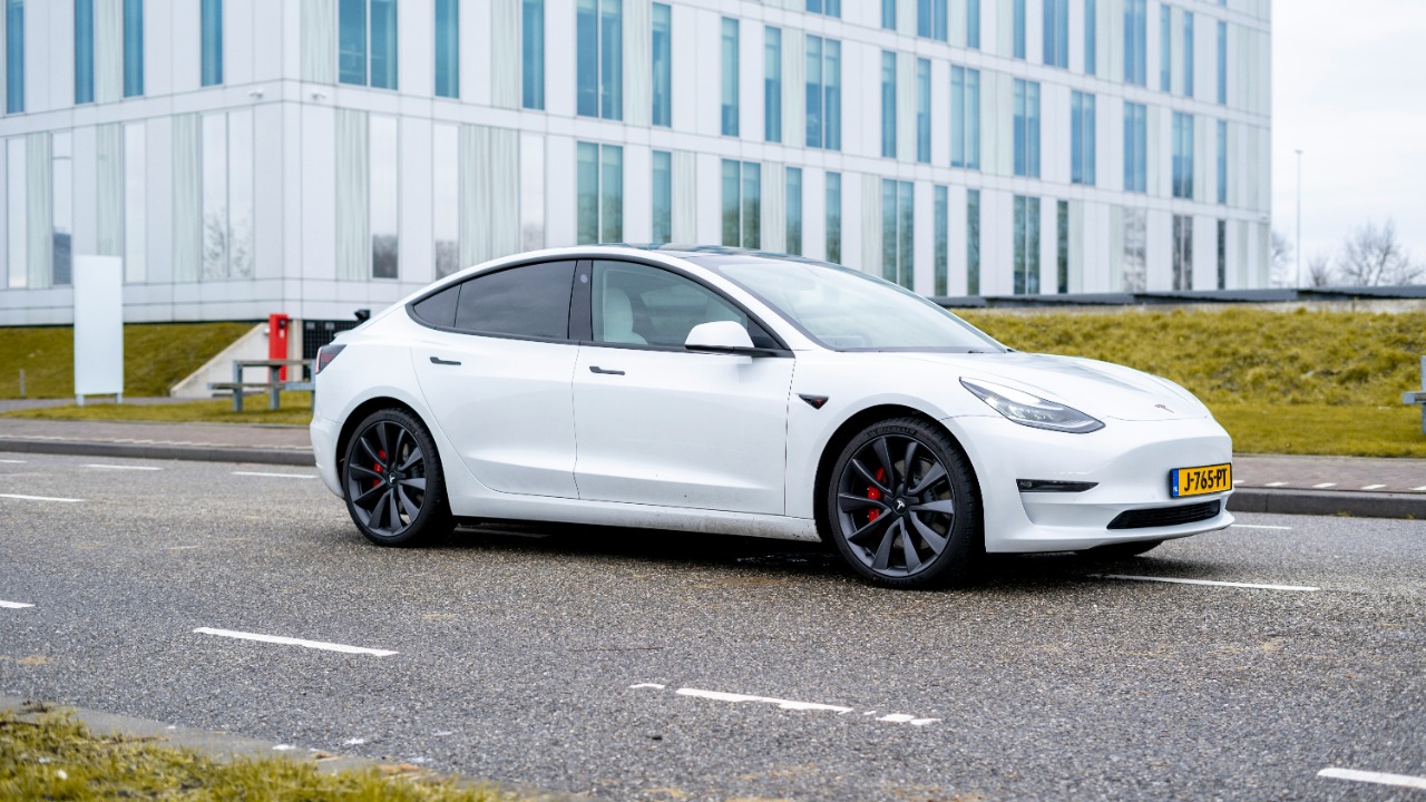 white sedan parked on gray asphalt road during daytime