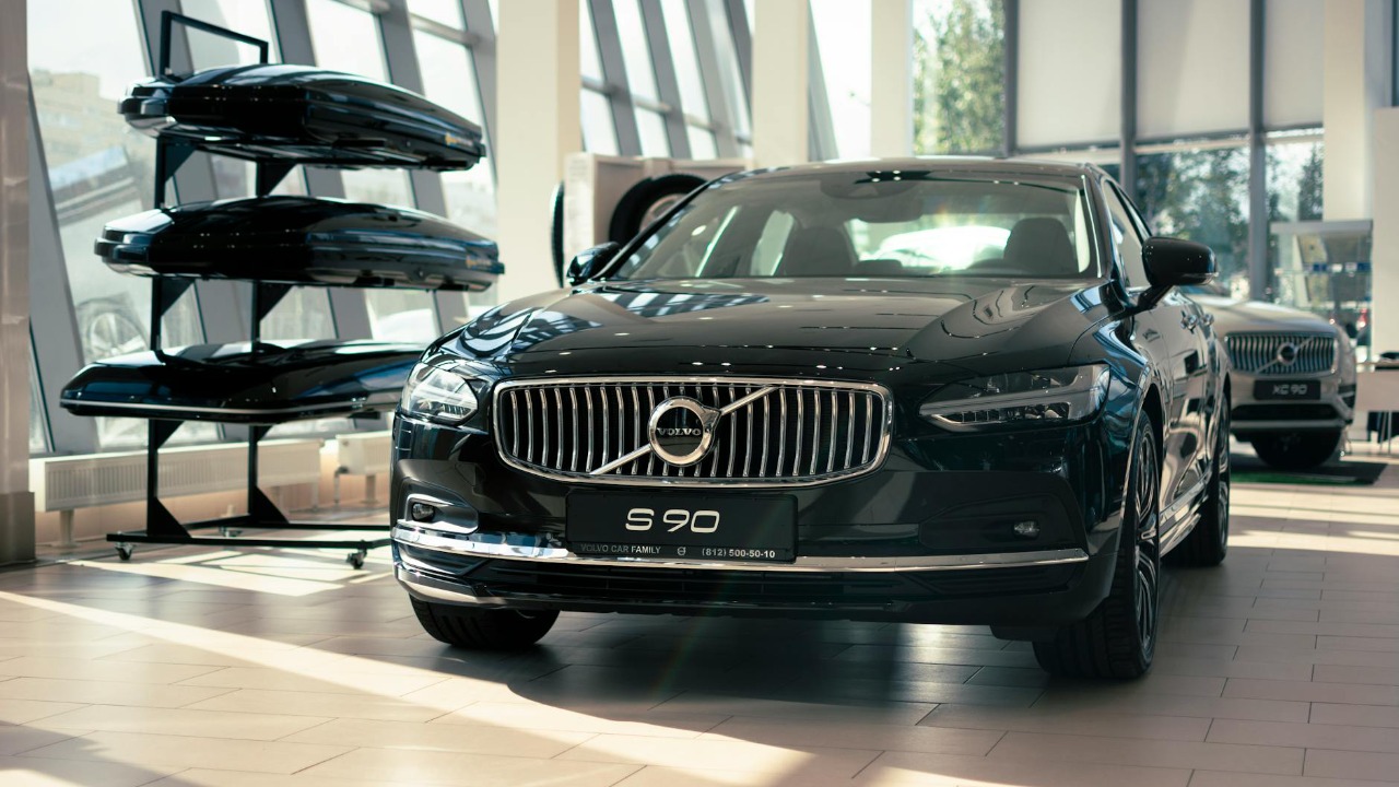 Elegant Volvo S90 on display in a modern car showroom with bright lighting and contemporary design.
