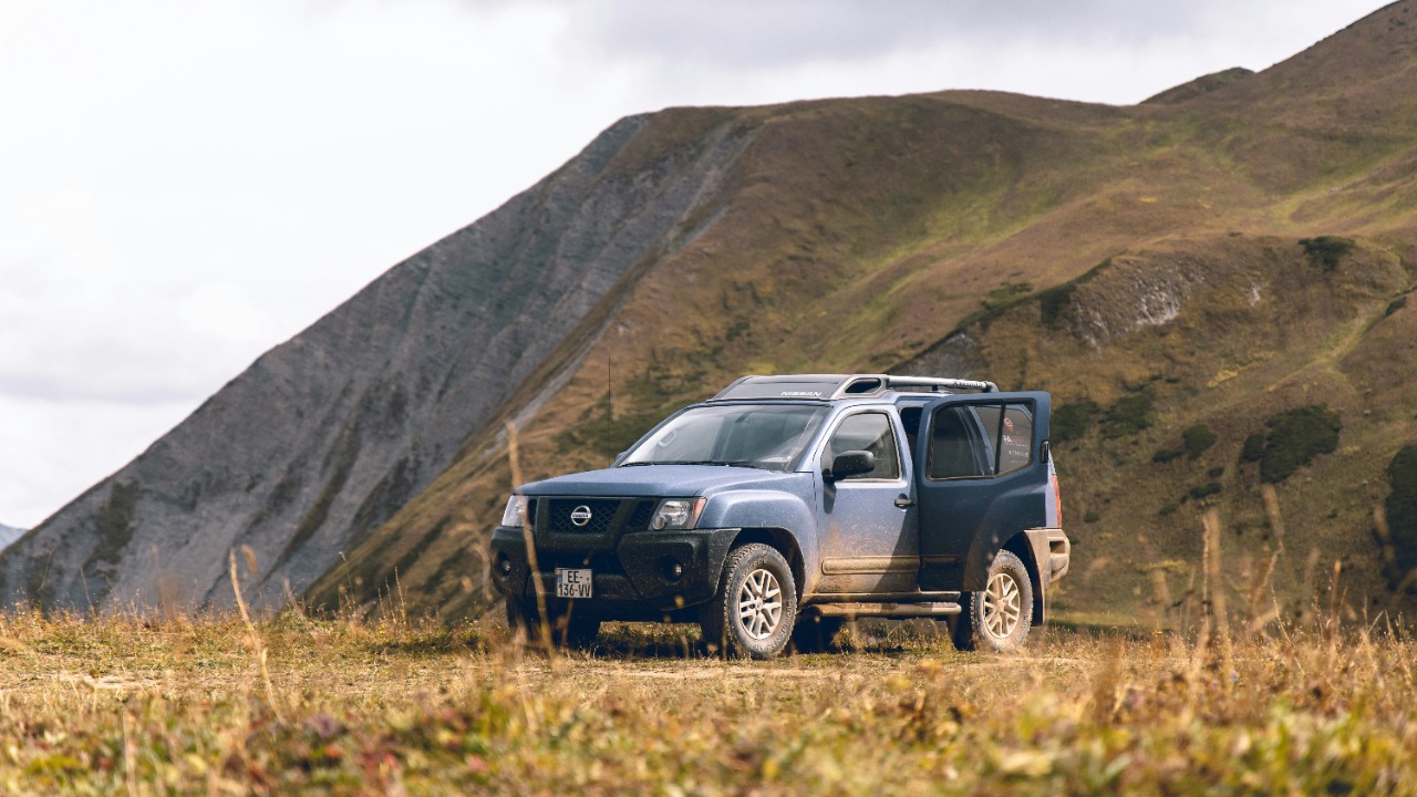white nad black vehicle parked beside mountain