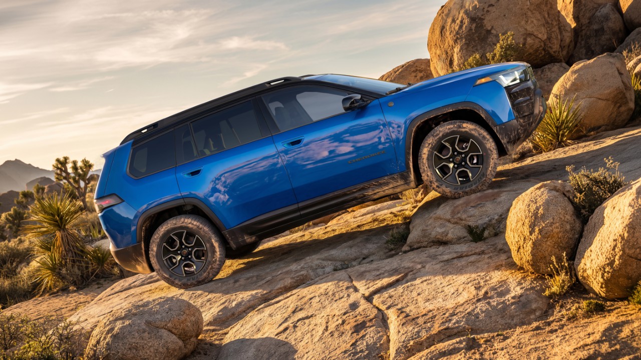 2027 Jeep Cherokee Trailhawk climbing a hill, seen from the side