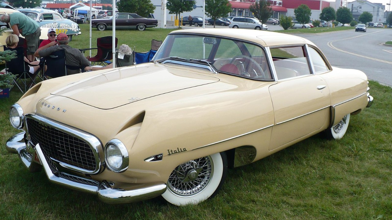 A cream 1954 Hudson Italia showing its wraparound windshield and fender scoops