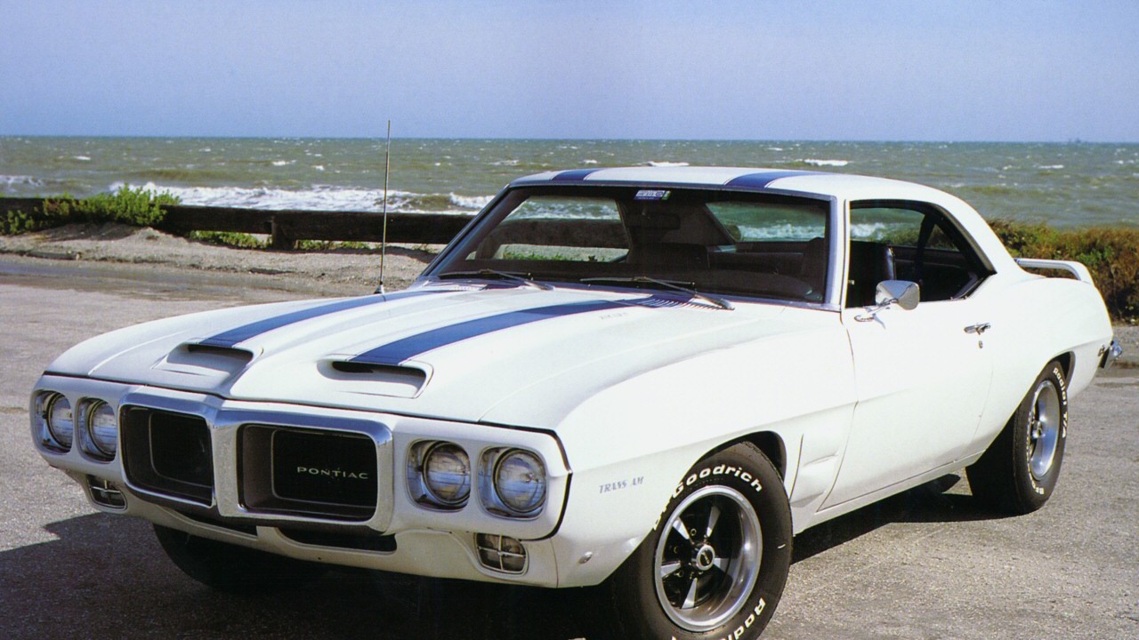A 1969 Pontiac Firebird Trans Am in white with blue stripes