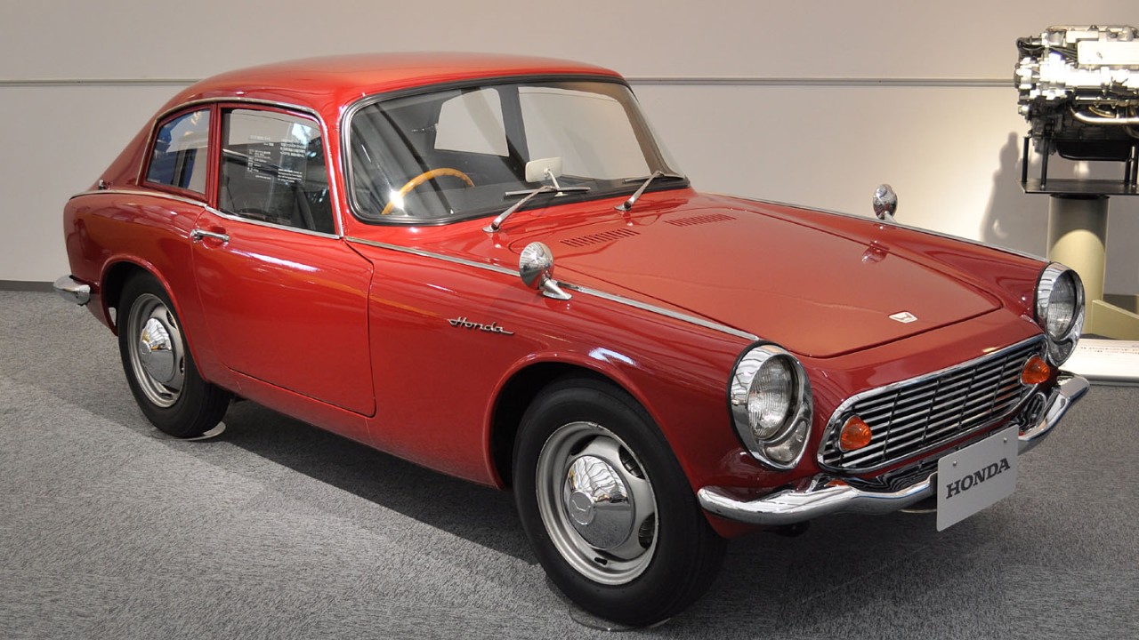 A red Honda S600 Coupe, a rare Japanese sports car with a fixed roof
